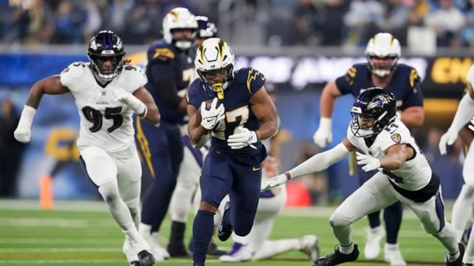 Los Angeles Chargers running back J.K. Dobbins (27) breaks past Baltimore Ravens safety Kyle Hamilton (14) during the first half of an NFL game on Monday, Nov. 25, 2024, in Inglewood, Calif. (AP Photo/Eric Thayer)